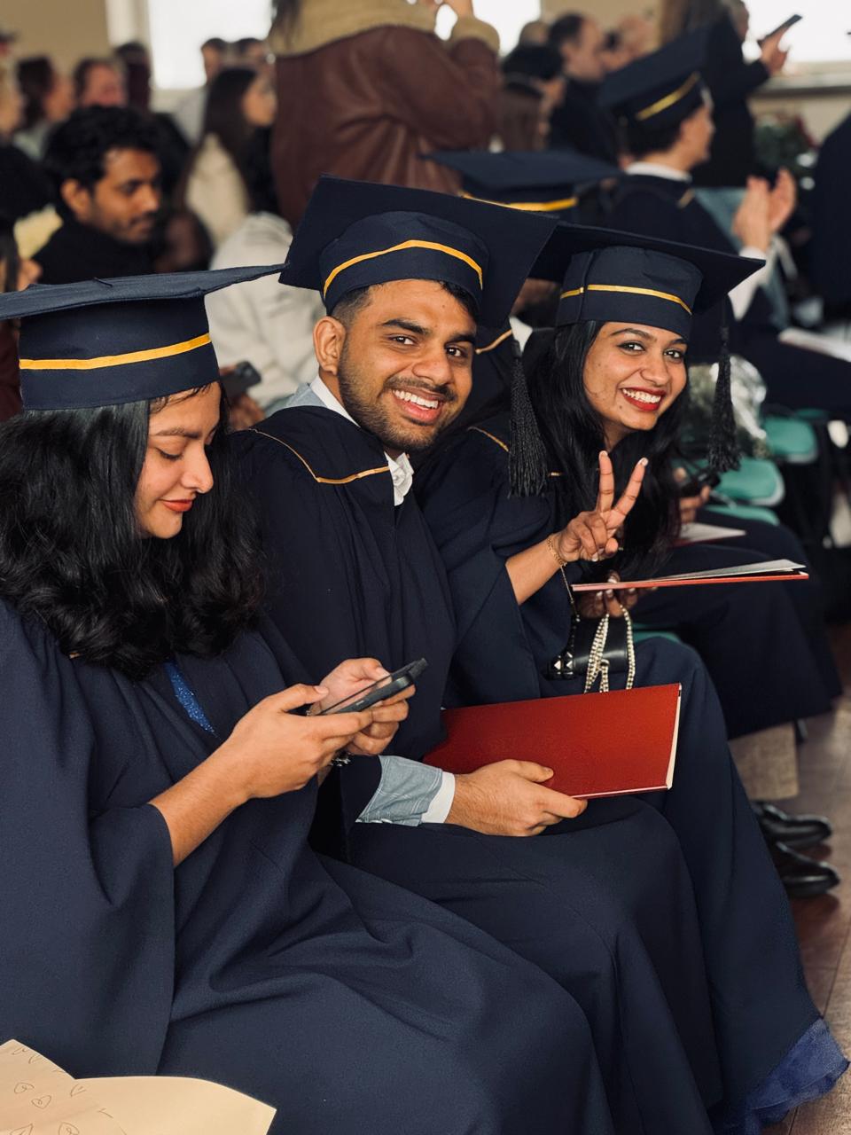 Three LevelUp students in graduation gowns, Lithuania